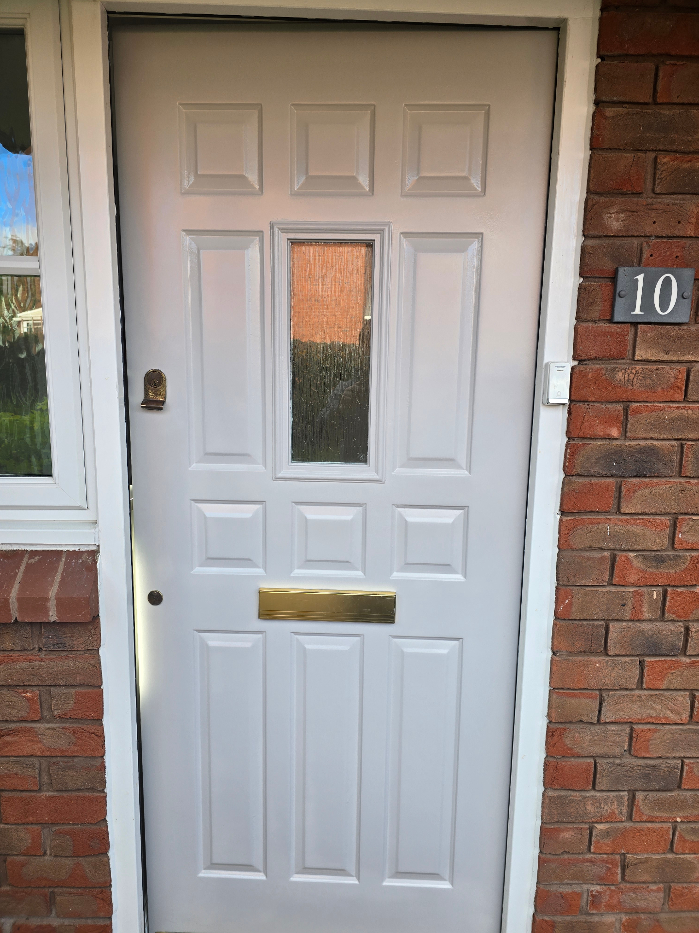Dark grey uPVC front door professionally sprayed and set into a red brick entrance with brass letterplate
