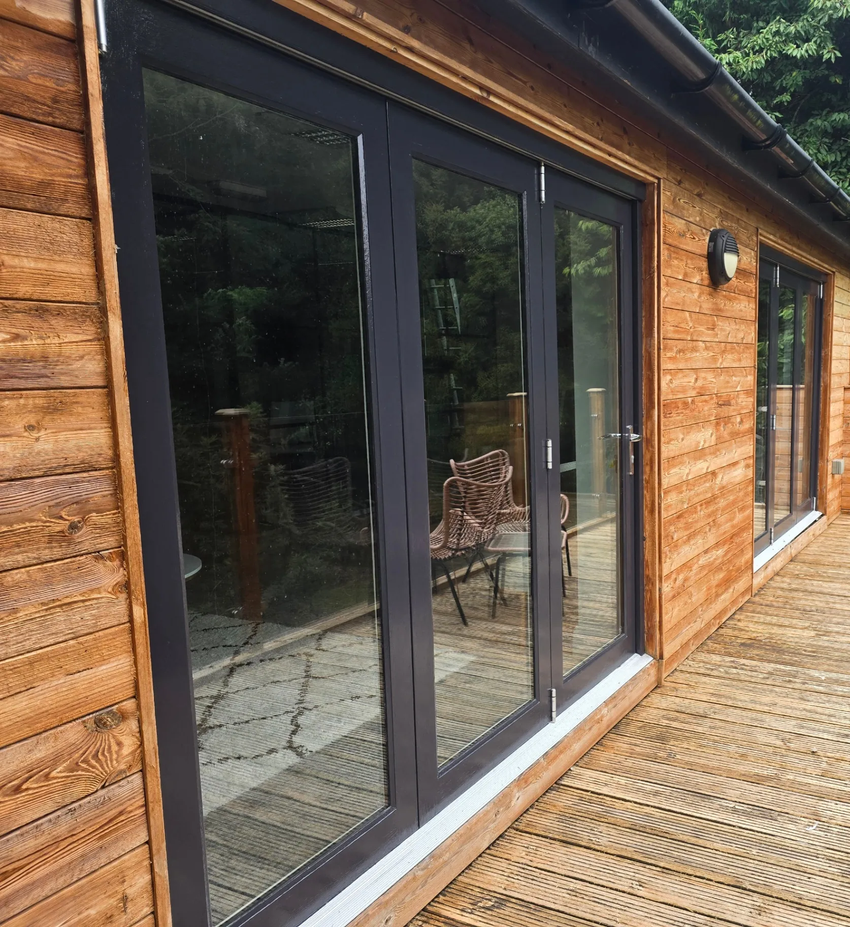 Contemporary timber-clad home extension featuring dark grey aluminum sliding doors