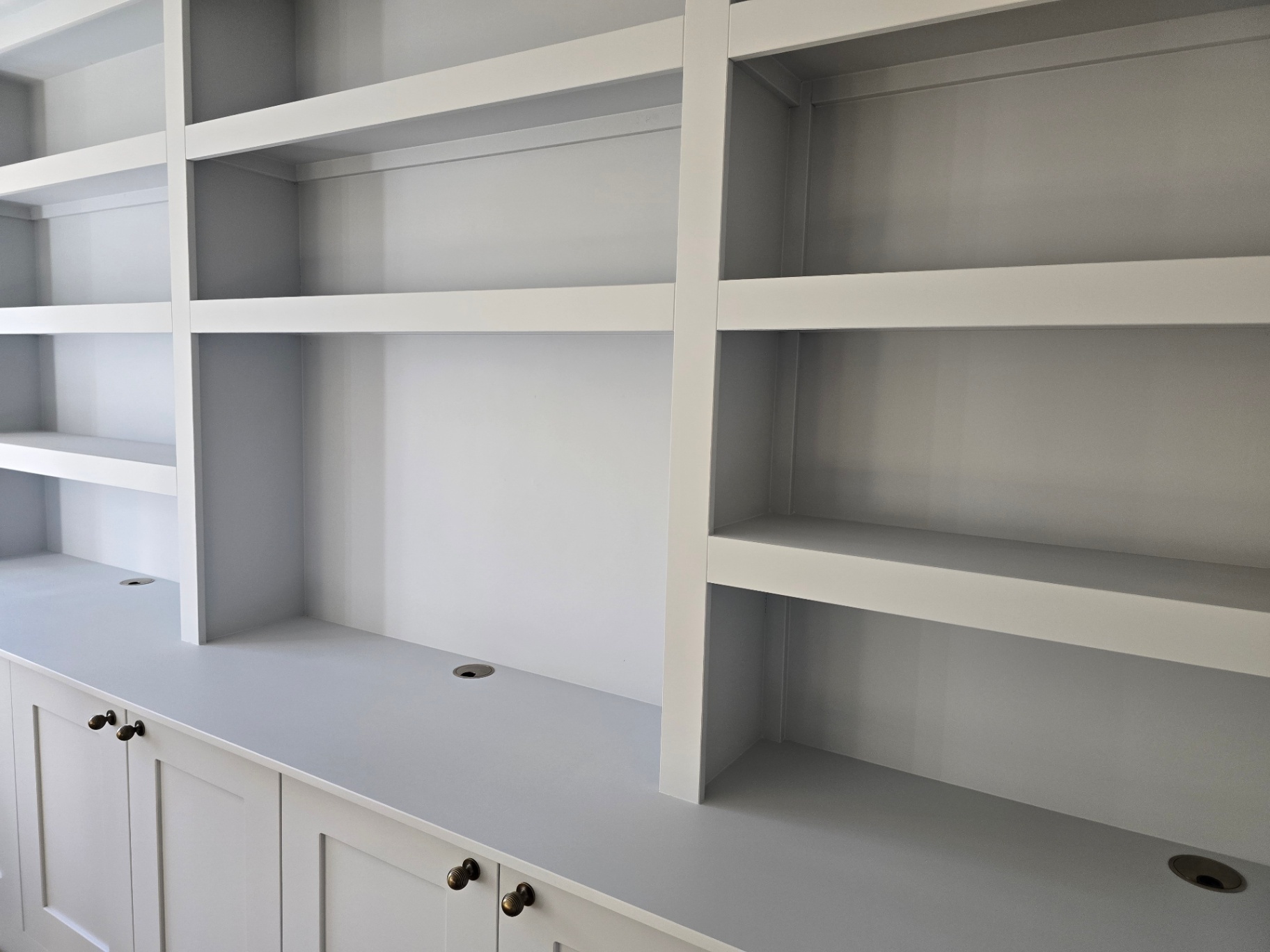 Custom living room media wall and shelving unit painted in an off-white finish