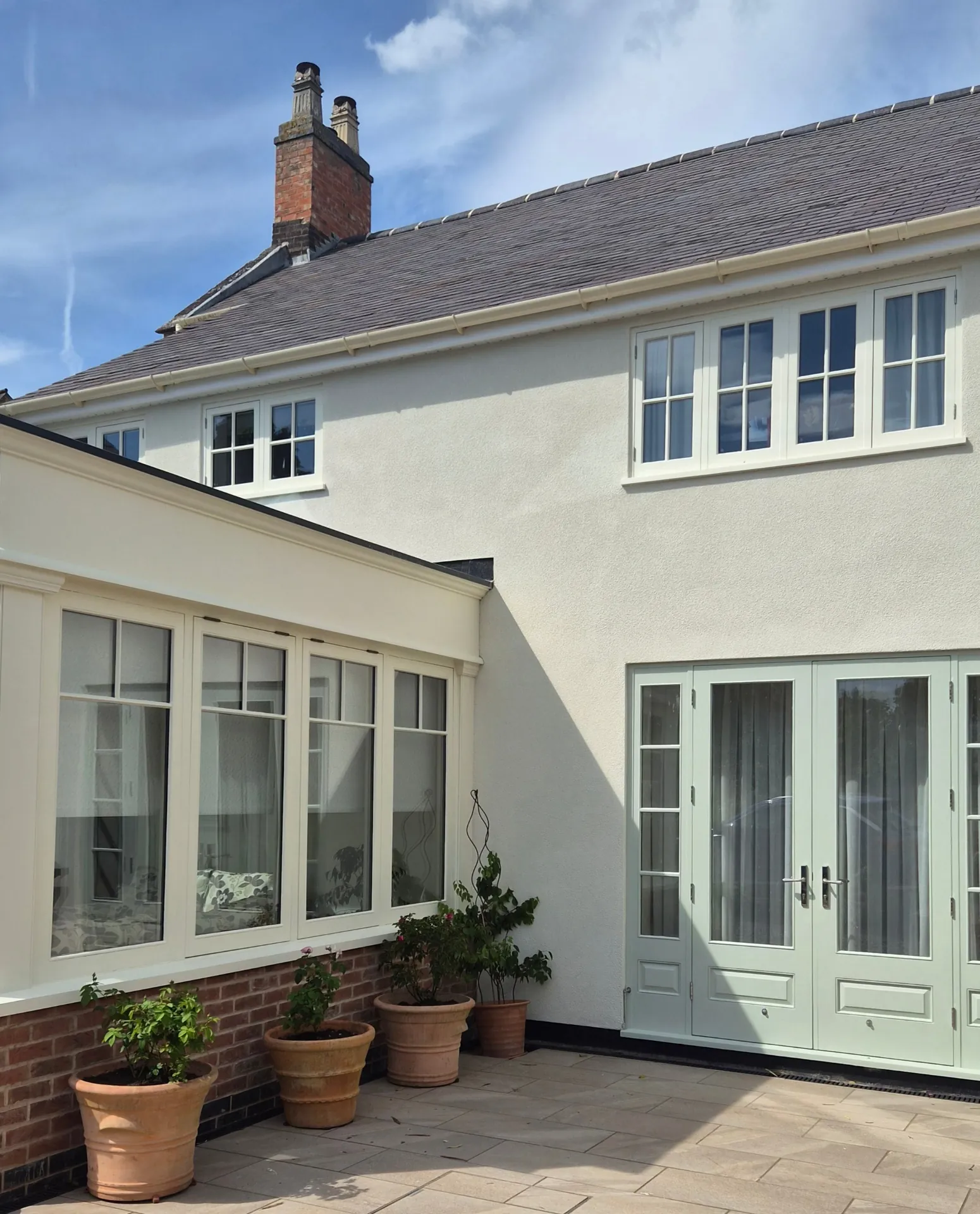 Exterior window and door painting in Kibworth, finished in Dulux Weathershield with soft sage French doors and cream casement windows