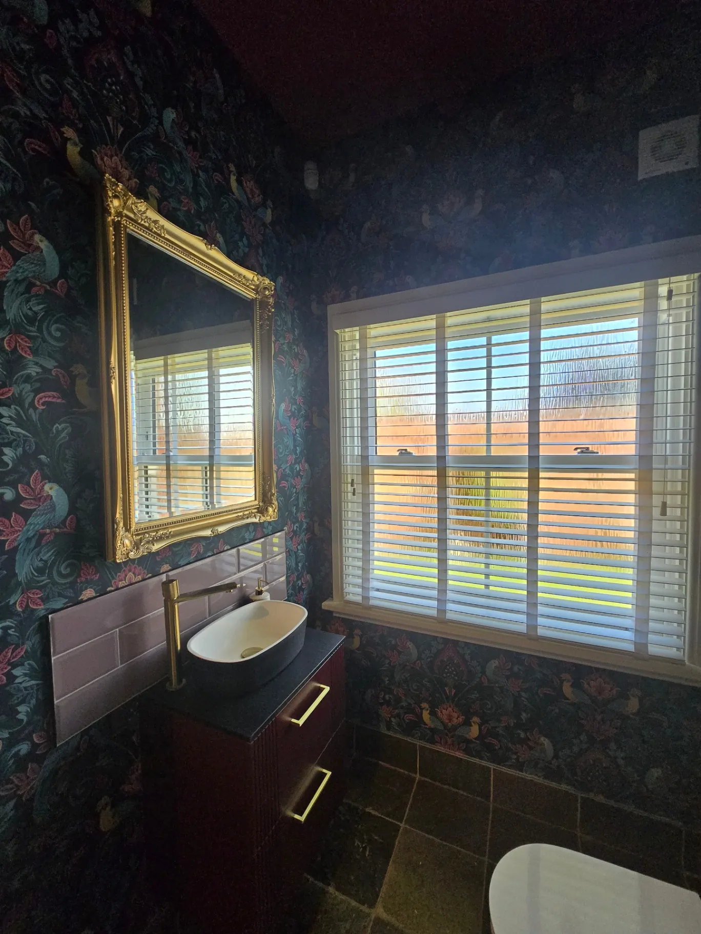 View from inside a room through a large multi-pane window frame painted in a dark premium finish