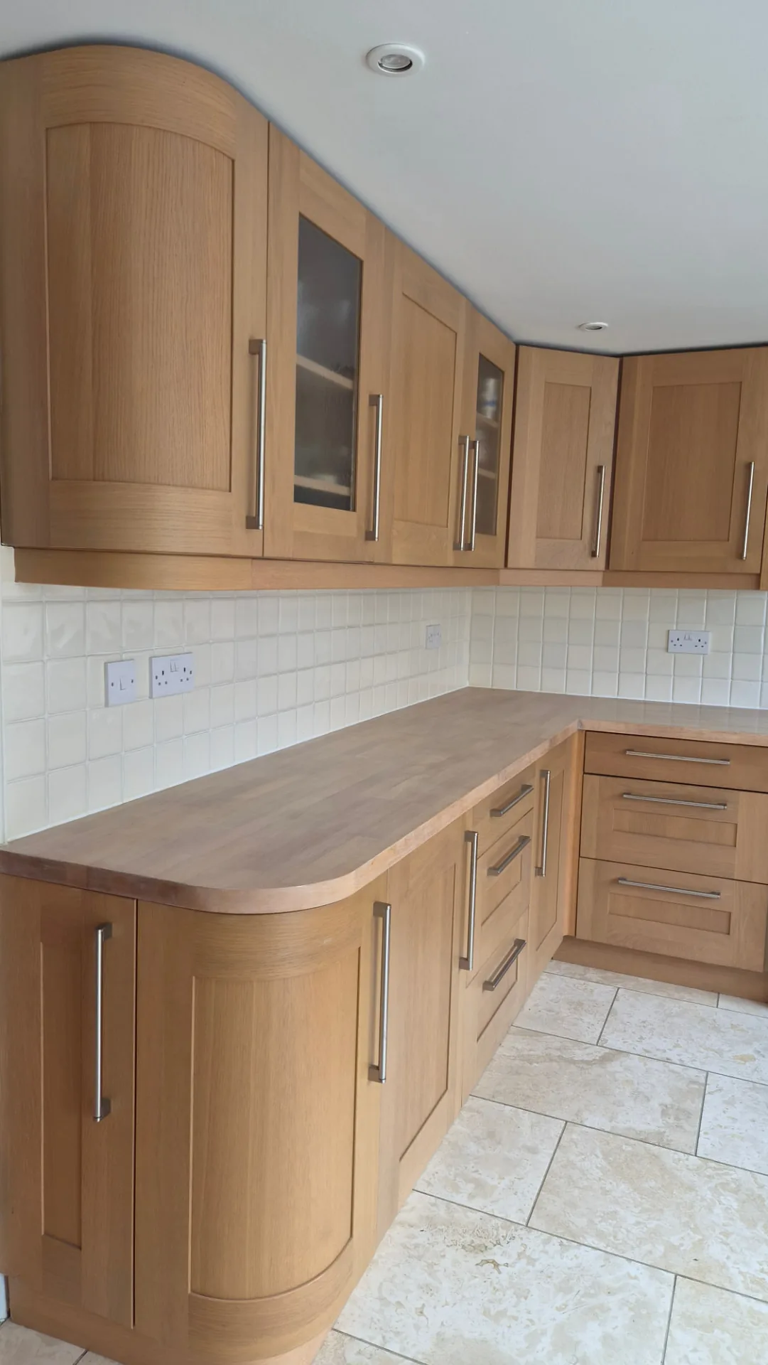 Oak shaker kitchen with curved end unit and glazed display cabinets before respraying, Leicestershire
