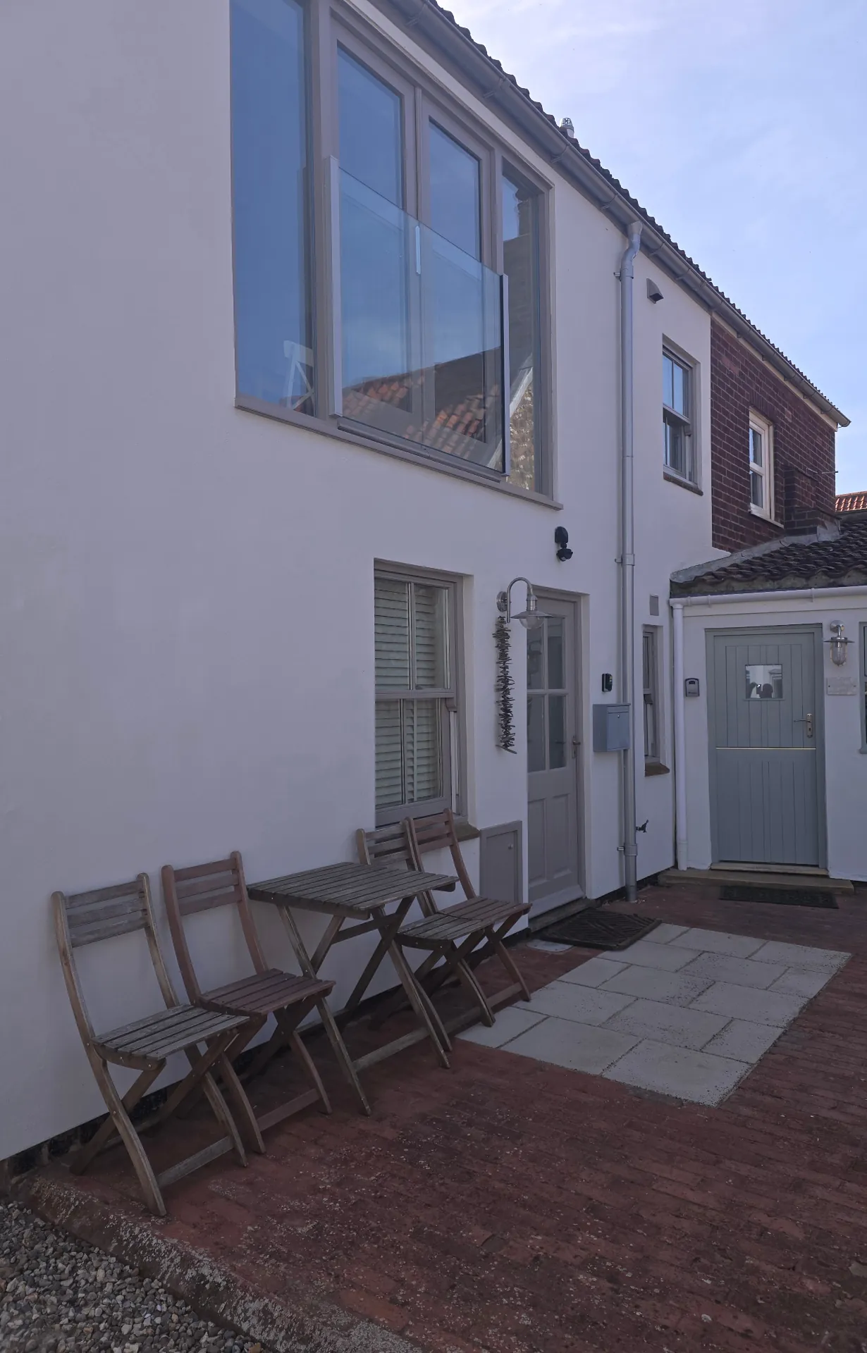 Modern residential property with crisp white render and uPVC windows contrast-sprayed in dark grey