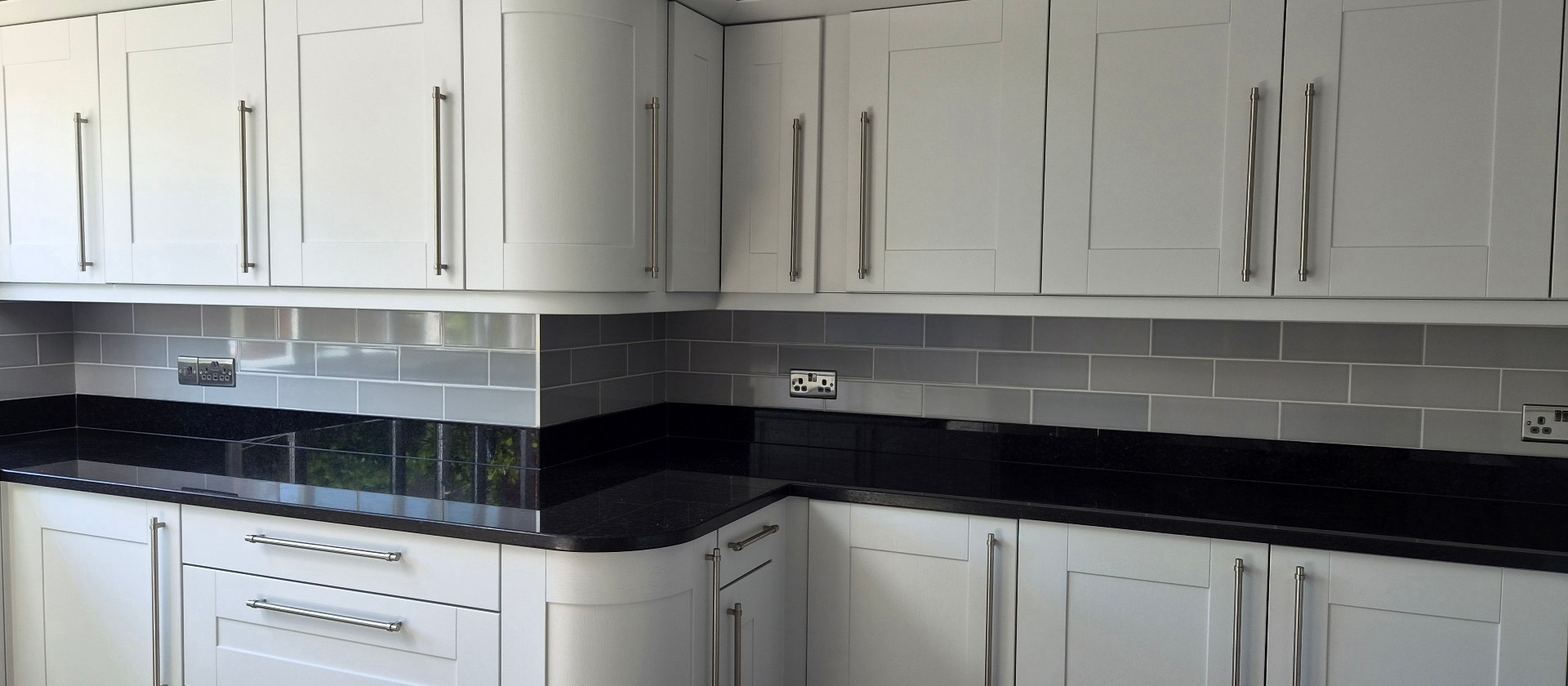 White shaker kitchen with black granite worktops professionally sprayed by Elite Decorators in Lutterworth, Market Harborough, Rugby and Hinckley