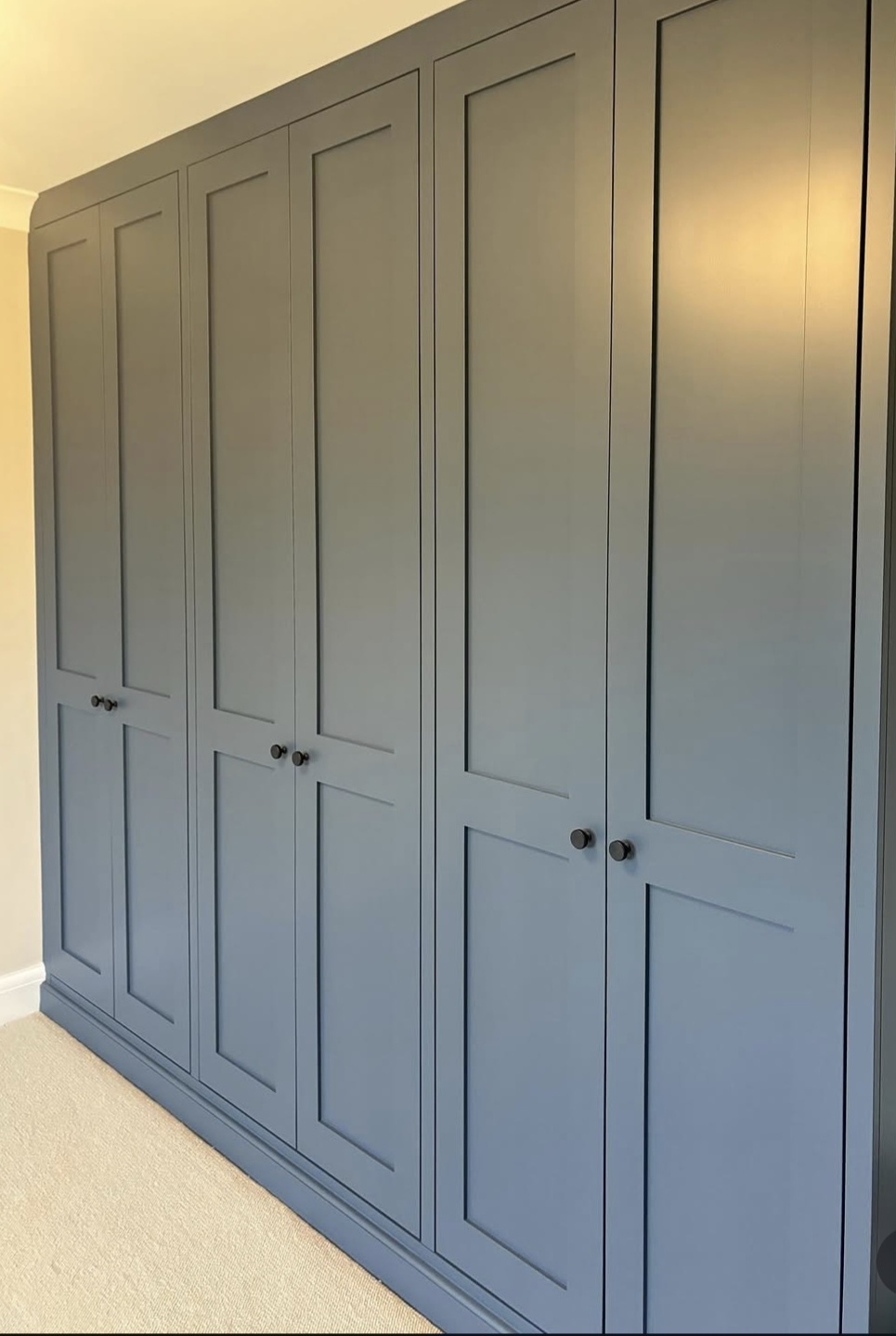 Bespoke fitted wardrobes spray-painted in a smooth grey finish with dark knobs — Leicestershire joinery spraying