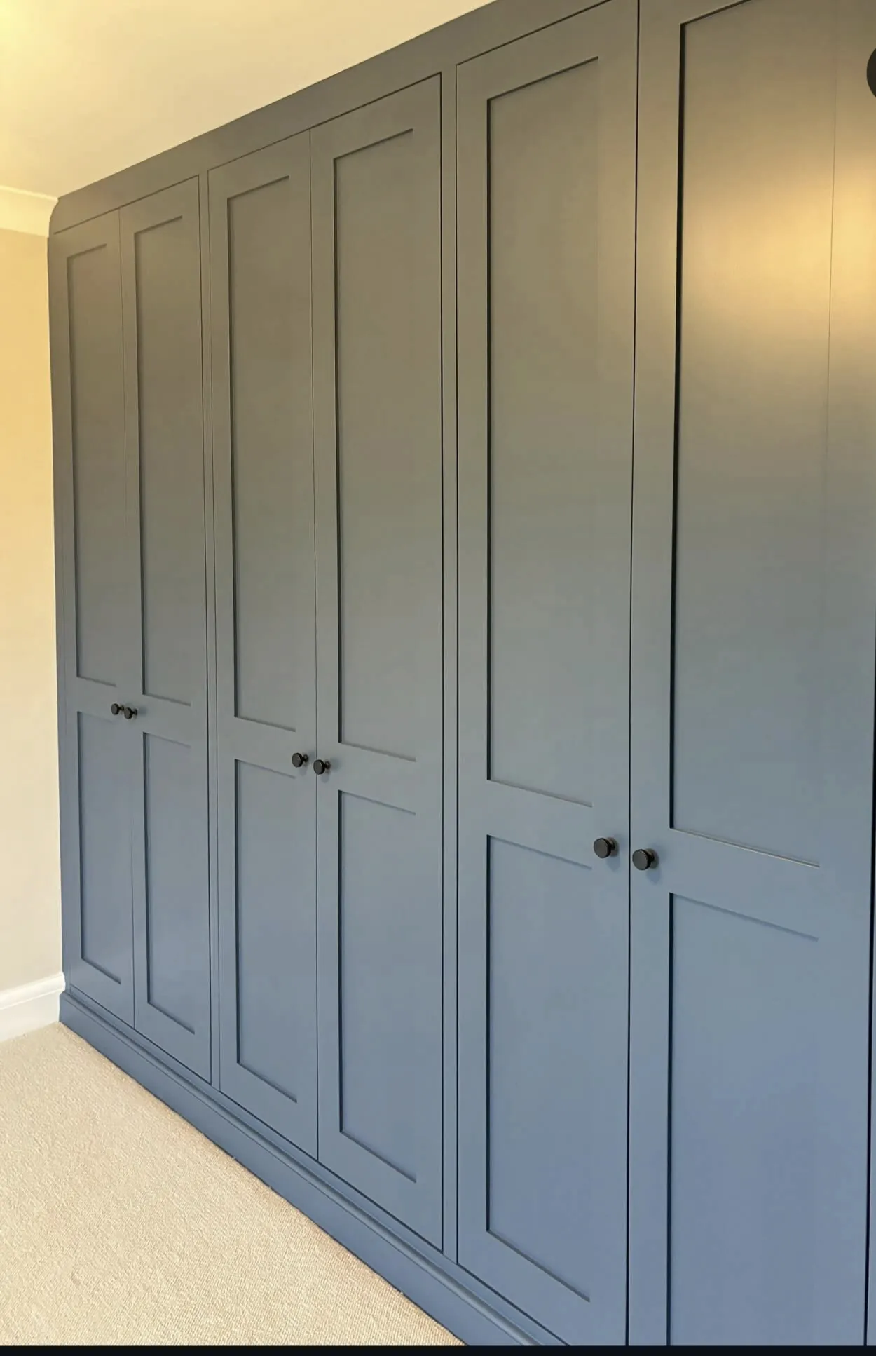 Built-in shaker wardrobes sprayed in Stiffkey Blue