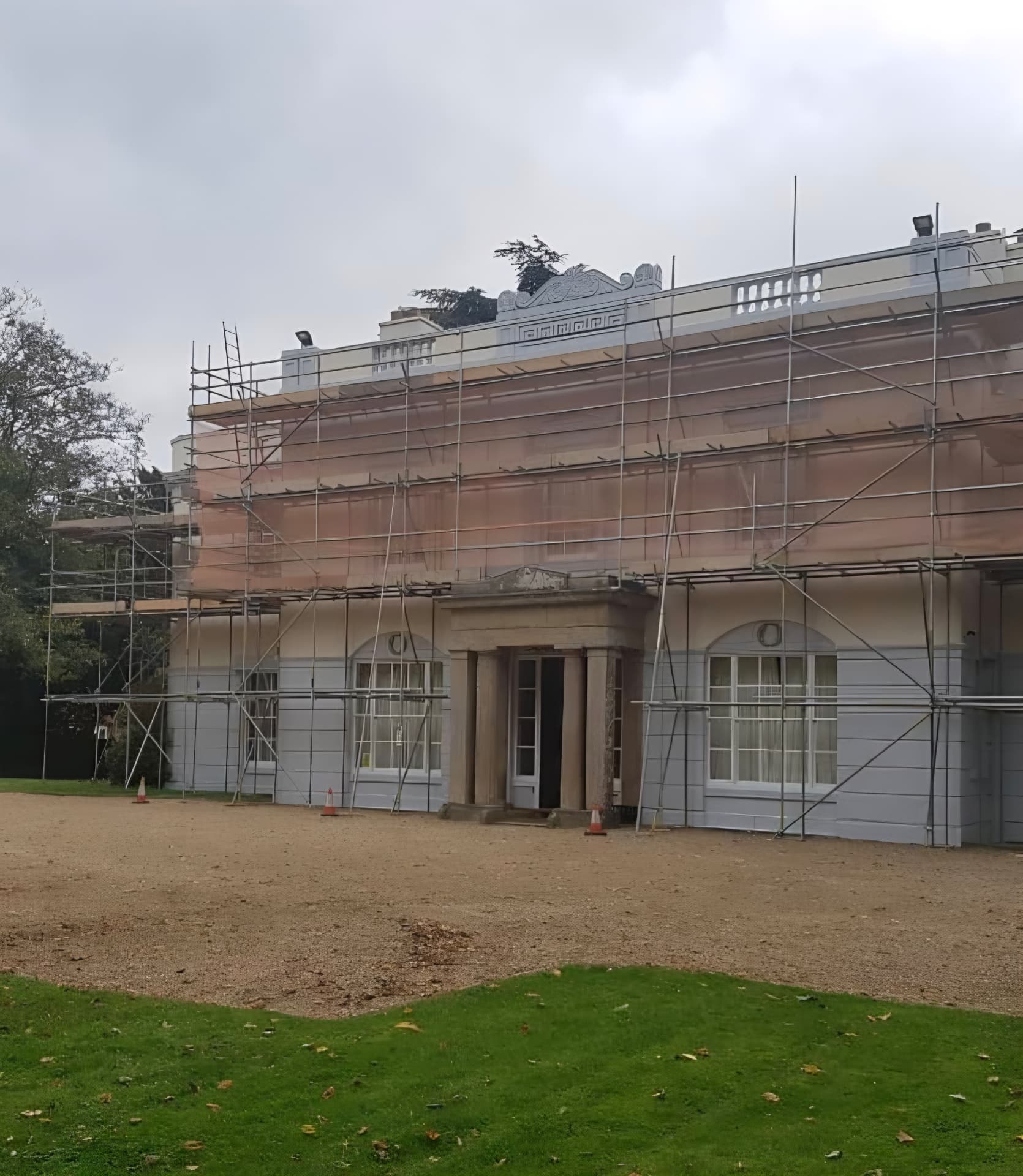Lutterworth Hall period building with scaffolding during a full render and window repaint, Leicestershire