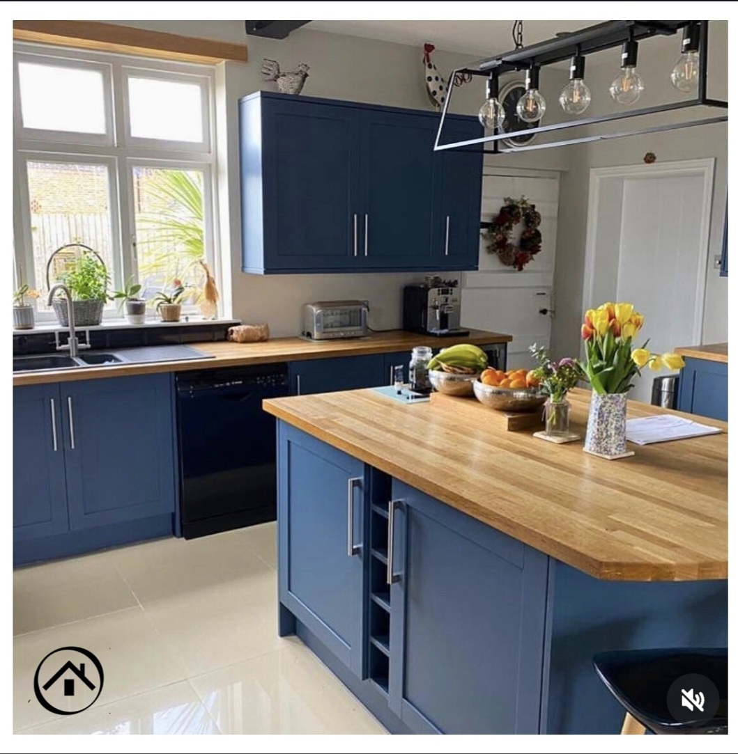 Bespoke kitchen featuring vibrant royal blue hand-painted cabinets and a solid wood island countertop